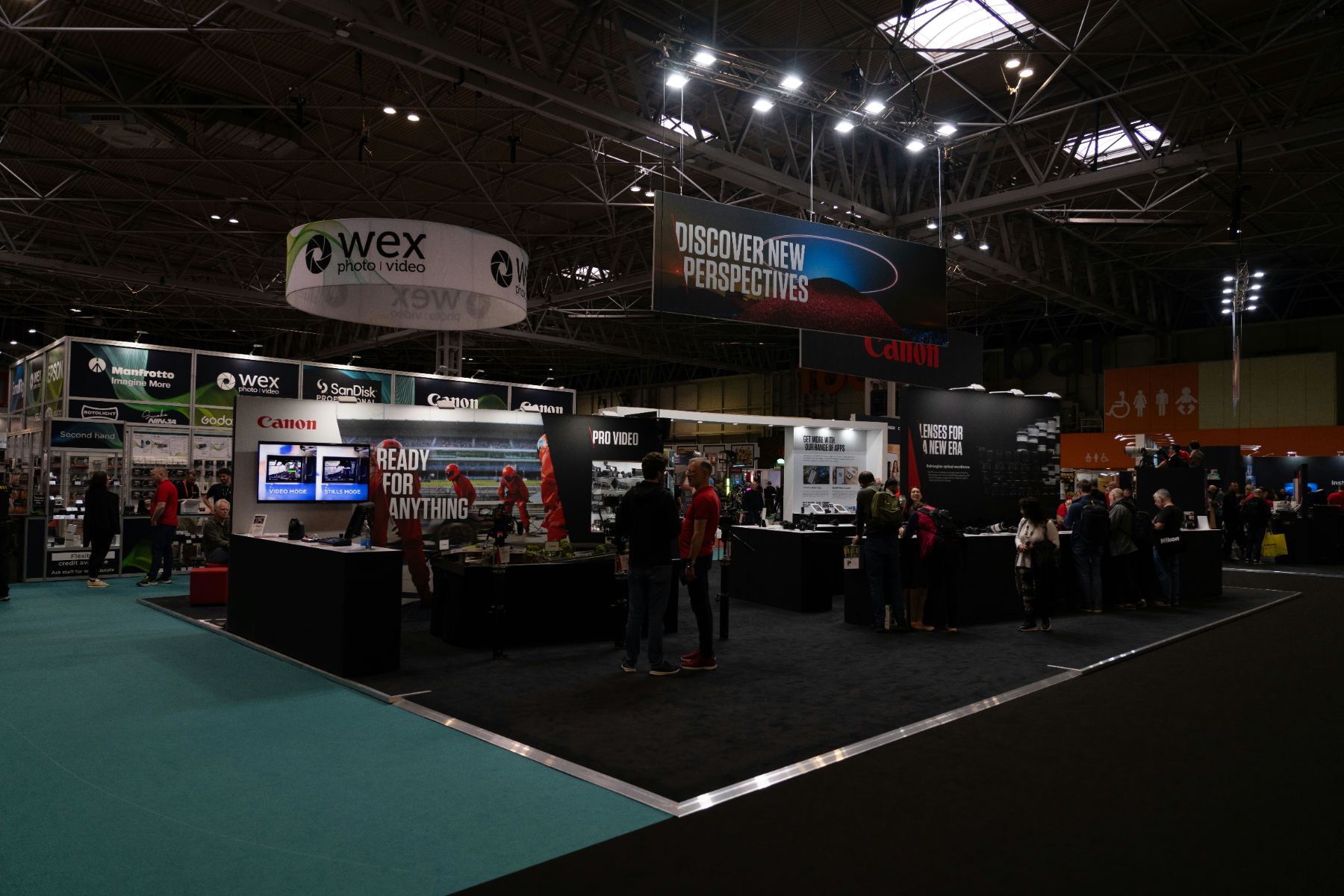 A wide view of an exhibition hall with rigged lighting and stands stretching into the distance.